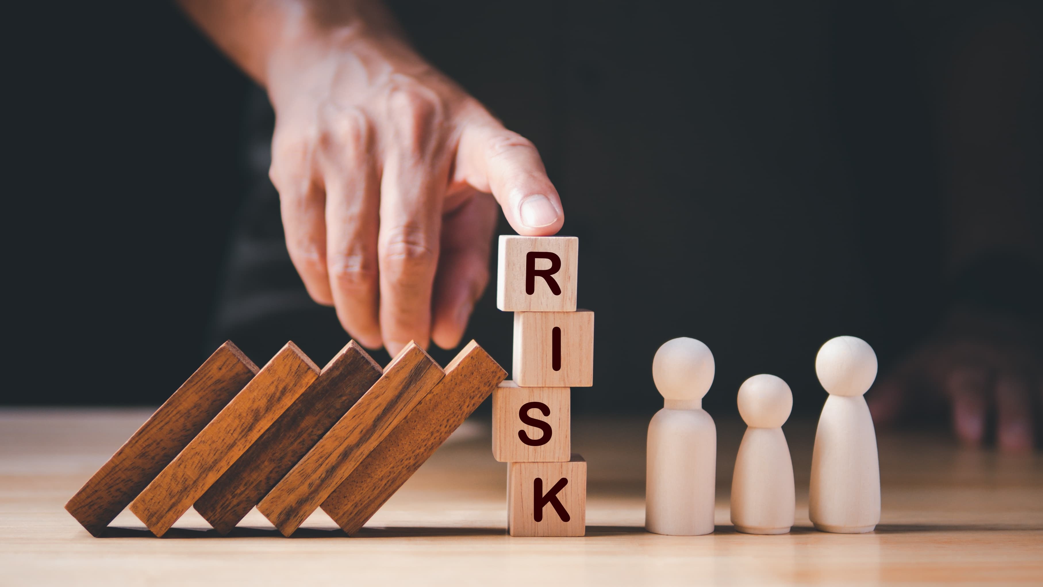 Kippende Holzblöcke, Würfelturm mit Buchstaben RISK verhindern Fall auf Figuren.