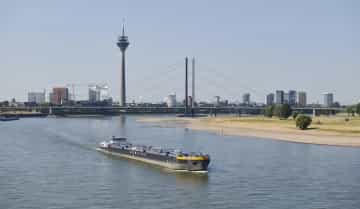 Aufnahme vom Rhein in Düsseldorf. Ein Tanker fährt auf dem Rhein und im Hintergrund steht der Fernsehturm.